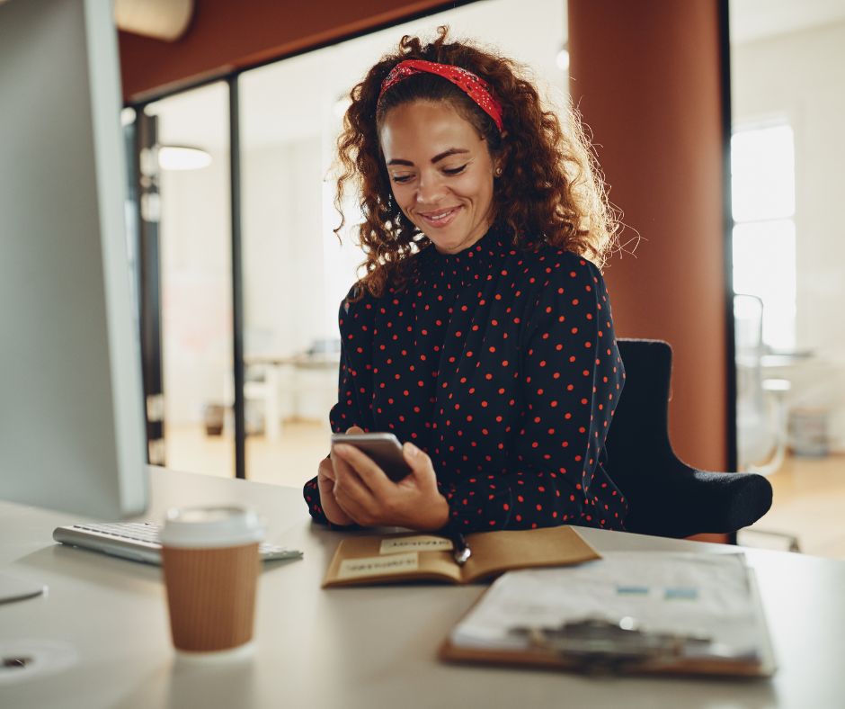 B2B sales professional researching target accounts and personalizing outreach on her phone in a modern office.