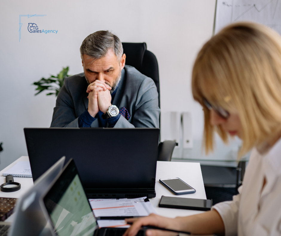 Executive reviewing sales performance data during discussion about increasing B2B sales conversions